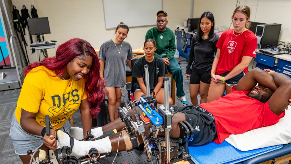 UNCG students work with various apparati in the Kinesiology Department's Applied Neuromechanics Lab during a KIN 376 Biomechanics class.